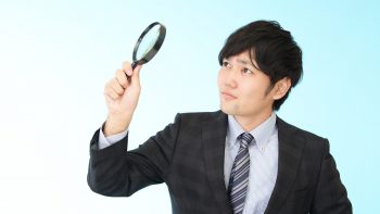 拡大鏡を持つビジネスマン