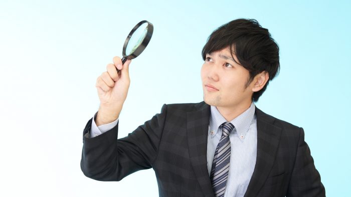 拡大鏡を持つビジネスマン